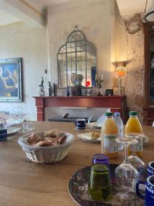 Ein Tisch mit einem Teller Essen und Flaschen Orangensaft in der Unterkunft Maison Dada et SPA in Meyssac