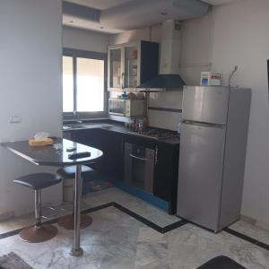 Il comprend une cuisine équipée d'un réfrigérateur et d'une table. dans l'établissement S1 Chat Mariem Vue Mer, à Hammam Sousse