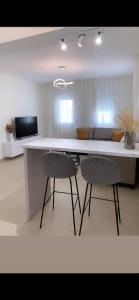 a kitchen with two chairs and a white counter at Milto's Apartment in Limenaria