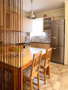 a kitchen with a wooden table and a refrigerator at Billmar Apartment in Tolo