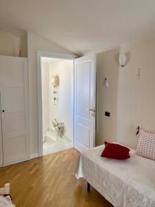 a white bedroom with a bed and a bathroom at Villa Serena in Monopoli