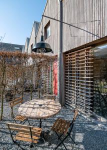a patio with a table and two chairs and a building at Les Camuches de la Coopérative in Tournai