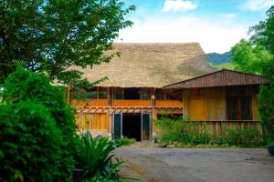 a house with a thatched roof and a yard at Healing Homestay Sapa in Sa Pa