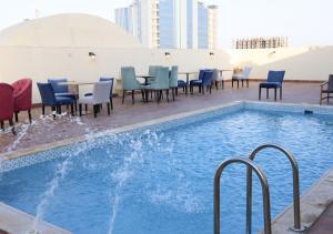 a pool on the roof of a building with chairs and tables at Al Fursan Al Mutahida Hotel فندق الفرسان المتحده in Jeddah