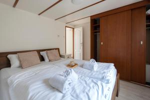 a bedroom with a large white bed with towels on it at 08, ontdek het bosrijke Oisterwijk met het grootste terras van Nederland! in Oisterwijk