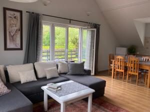 een woonkamer met een bank en een tafel bij Apartament w Domu Wypoczynkowym Zacisze in Stegna