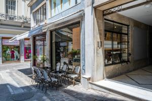 a cafe with chairs and a table in front of a building at Athensis Acropolis View next to Ermou street! in Athens