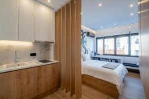 a bedroom with a bed and a sink and a bathroom at Athensis Acropolis View next to Ermou street! in Athens