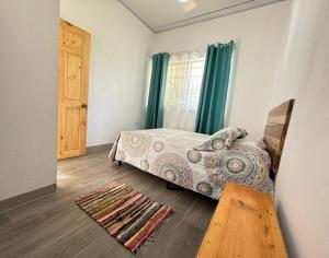 a bedroom with a bed and a wooden floor at Serenity Houses in Cahuita