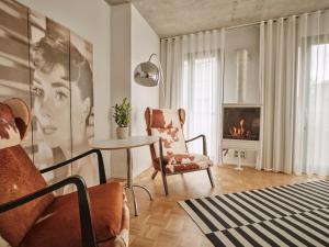 uma sala de estar com uma mesa, uma cadeira e uma lareira em BANKS Antwerp em Antuérpia