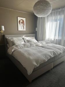 een slaapkamer met een wit bed en een groot raam bij Lovely home in maritime surroundings near Stavanger in Stavanger