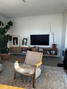 een woonkamer met een stoel en een flatscreen-tv bij Lovely home in maritime surroundings near Stavanger in Stavanger