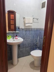 丹吉尔Complexe safae的带水槽、马桶和镜子的浴室