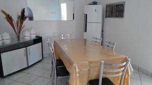 a kitchen with a table with chairs and a refrigerator at Blue House in Lençóis