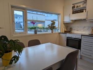 a kitchen with a table with chairs and a window at Green appartement in Sandnes