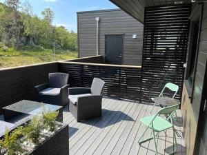 a deck with chairs and chairs and a table at Moderne leilighet fra 2019 in Sandnes