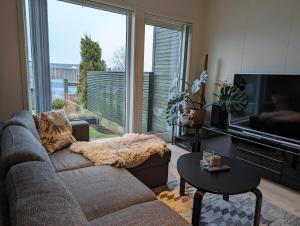 a living room with a couch and a large window at Green appartement in Sandnes