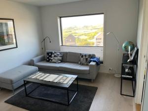 a living room with a couch and a window at Moderne leilighet fra 2019 in Sandnes
