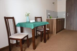 a kitchen with a table and two chairs and a counter at Pokoje gościnne GRYF in Rewal
