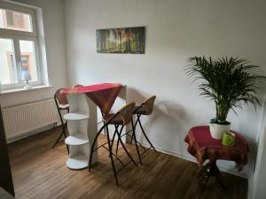a room with chairs and a table and a plant at FeWo Am Tummelplatz in Blankenburg