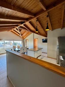 an open kitchen and dining room with wooden ceilings at Antu Mahuida Apartments in San Carlos de Bariloche