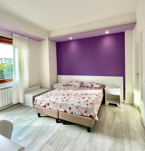 a bedroom with a bed and a purple wall at Sogna Firenze apartments in Florence