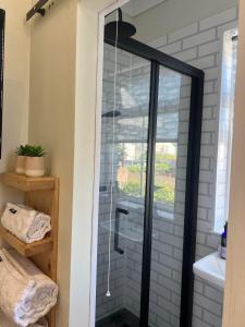 a shower with a glass door in a bathroom at Ocean Reach in Porthcawl