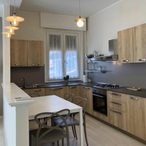 a kitchen with wooden cabinets and a table and chairs at Top Stay - Lakes, Mountains, Valley & More in Costa Volpino