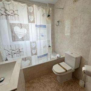 a bathroom with a toilet and a tub and a shower at Kesito Family Apartments in Lloret de Mar