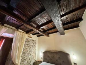 a bedroom with a bed and wooden ceilings at AL CARDINALE in Fondi