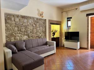 a living room with a couch and a stone wall at AL CARDINALE in Fondi