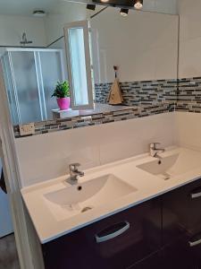 a bathroom with two sinks and a large mirror at chambre chez hôte 1 in Carbon-Blanc
