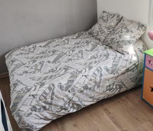 a bed in a corner of a room with a bedsheet at chambre chez hôte 1 in Carbon-Blanc