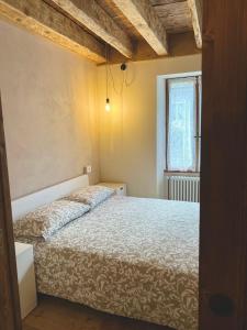 a bedroom with a bed and a window at Appartamento Zeli e Old Alagna in Alagna Valsesia