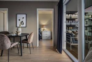a dining room with a table and chairs and a bedroom at Moderne leilighet i Lørenveien in Oslo