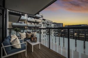 a balcony with a couch and a view of a building at Moderne leilighet i Lørenveien in Oslo