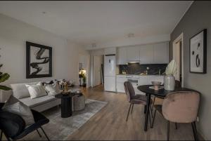 a living room with a couch and a table at Moderne leilighet i Lørenveien in Oslo +9 photos