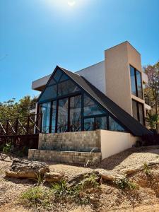 a house with glass windows on the side of it at Chalés Piribless-Ikigai in Pirenópolis