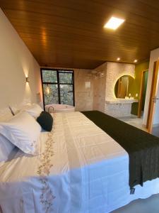 a large white bed in a room with a window at Chalés Piribless-Ikigai in Pirenópolis