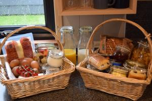 two baskets of food on a counter with bread and orange juice at Oakwood Escapes in North Cliff