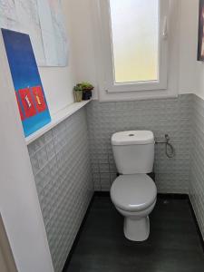 a bathroom with a white toilet and a window at Chambre chez hôte 2 in Carbon-Blanc +3 photos