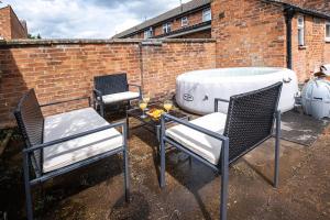 a backyard with two chairs and a bath tub at Cozy Nook-Hot Tub, Sleeps 8, Free Parking, Netflix in Leicester