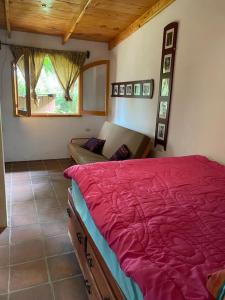 een slaapkamer met een bed, een bank en een raam bij Peaceful Hideaway in Santa Cruz La Laguna