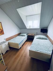 two beds in a room with a attic at Noclegi u Zygmunta in Mielno