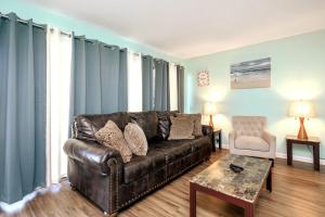a living room with a leather couch and a table at Kings Cove Central Destin 3 Community Pools in Destin