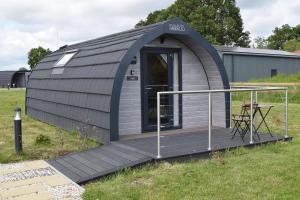 a dome tent with a deck in a field at Oakwood Escapes in North Cliff