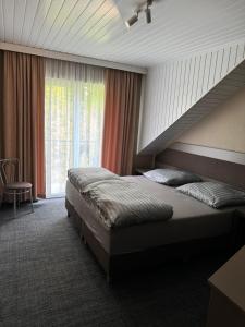 a bedroom with a large bed and a window at Costa Mielno in Mielno