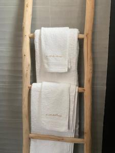 ein Handtuchhalter mit vier weißen Handtüchern darauf in der Unterkunft La Clé des Champs Maison familiale à 15min Disneyland Paris WIFI GRATUIT in Boutigny