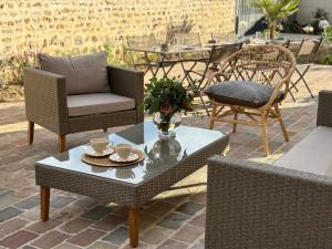 eine Terrasse mit Stühlen und einem Tisch mit Tassen darauf in der Unterkunft La Clé des Champs Maison familiale à 15min Disneyland Paris WIFI GRATUIT in Boutigny