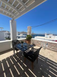 a patio with a table and chairs on a roof at Katerina Apartments & Studios in Naousa